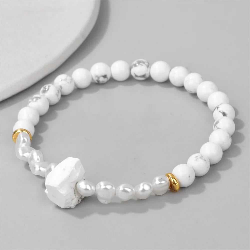 Weiße Perlenarmband mit goldenen Akzenten, Howlith und Süßwasserperlen, elegantes Schmuckdesign.