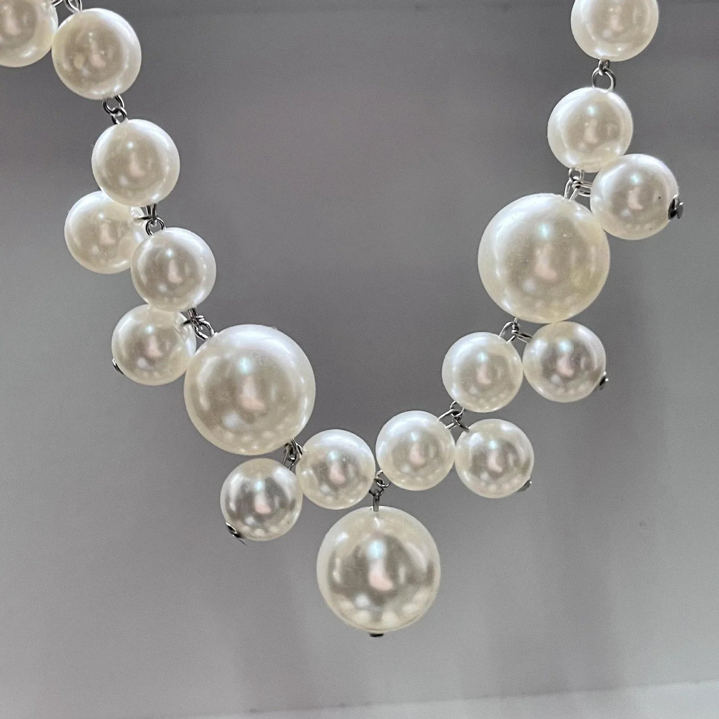 Perlenkette aus weißen Kunstperlen, elegantes Schmuckstück, modisches Accessoire für Damen.