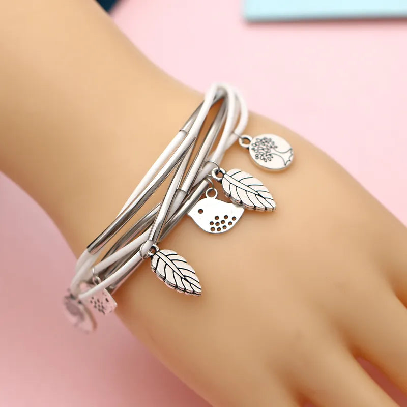 Silberarmband mit Blatt- und Vogelanhängern, Damenmode, eleganter Schmuck, Geschenkidee.