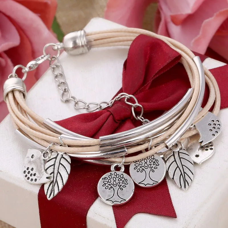 Mehrschichtiges Armband mit silbernen Baum- und Blattanhängern, beige Leder, Geschenkbox.