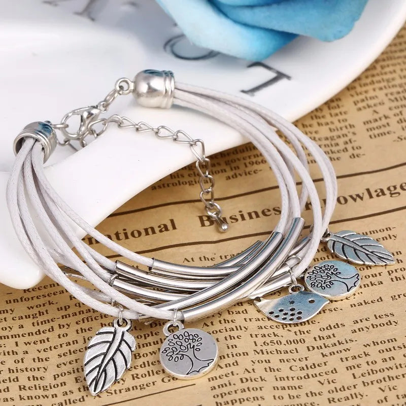 Silber-Armband mit weißen Lederbändern und Blattanhängern, modisches Damen-Schmuckstück.