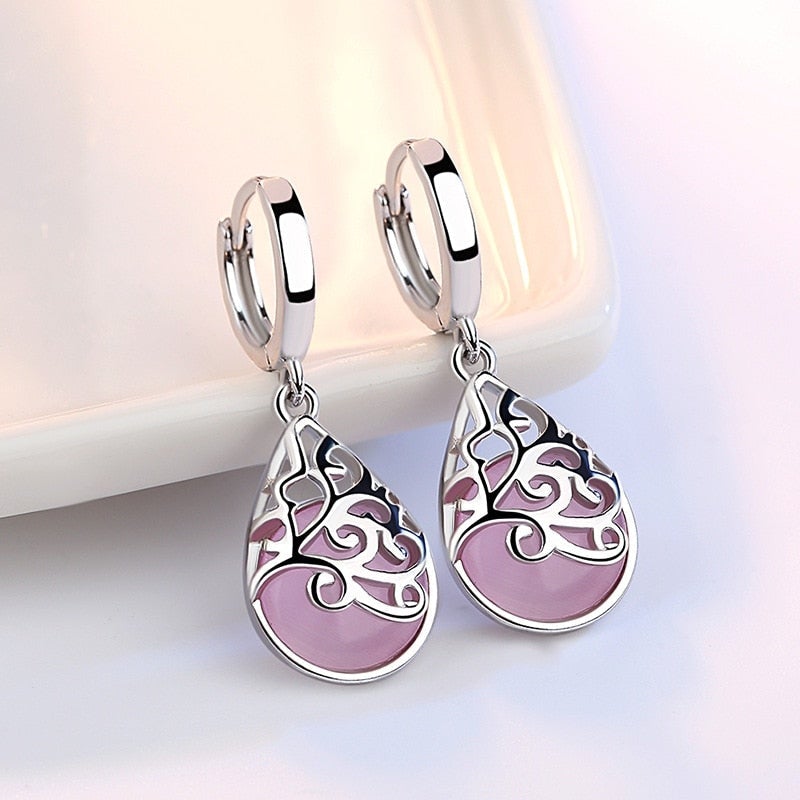 Silberne Ohrringe mit rosa Tropfenanhänger, filigranes Design, modischer Schmuck.