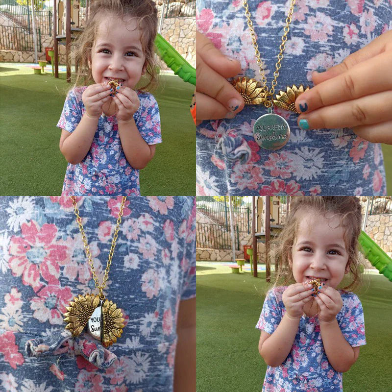 Mädchen mit Sonnenblumen-Halskette, blauer Blumen-Kleid, Spielplatz im Hintergrund.