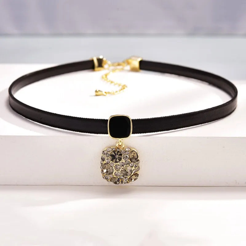 Schwarzes Lederhalsband mit goldfarbenem Anhänger, Damenmode, eleganter Schmuck.