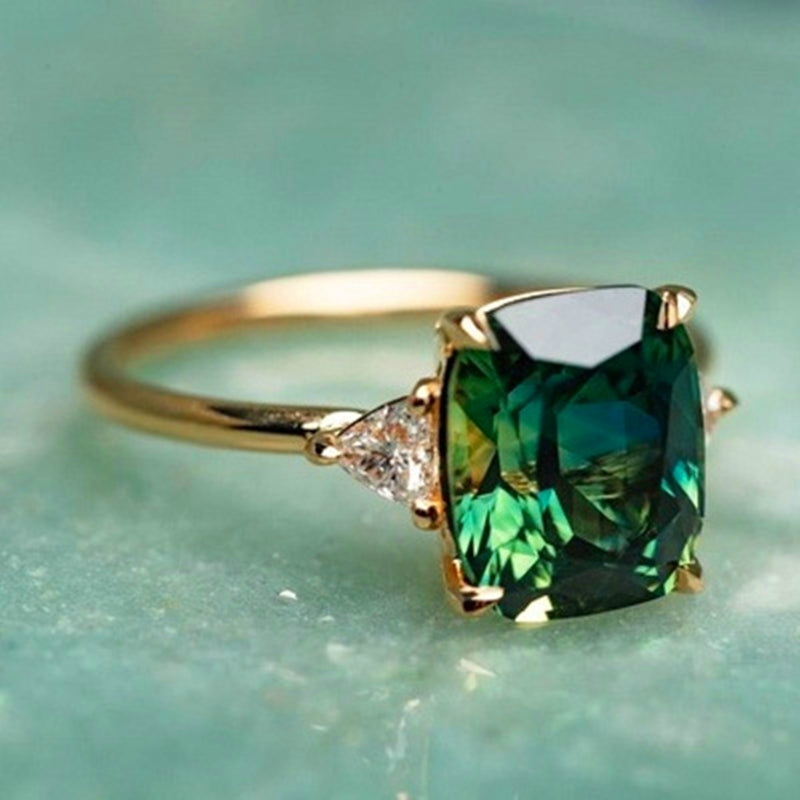 Goldring mit grünem Smaragd und Diamanten, luxuriöser Schmuck, elegantes Design.