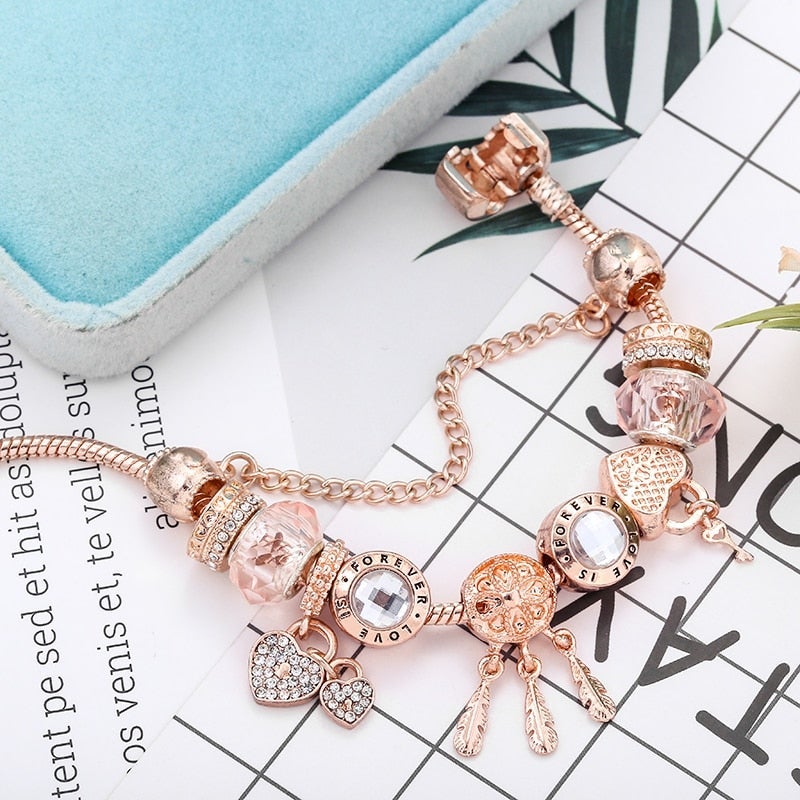 Roségoldenes Armband mit Kristallanhängern, Herz- und Federdesign, modisch, elegant.