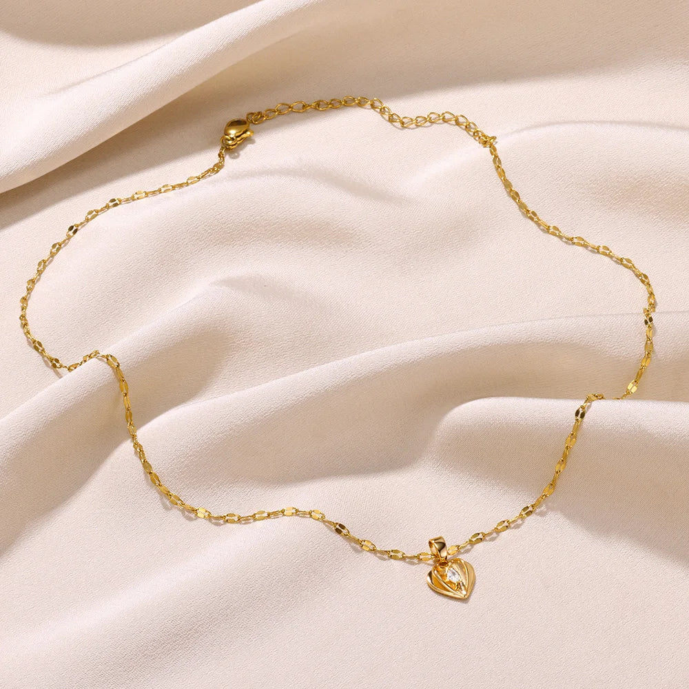 Goldene Halskette mit Herzanhänger auf beigem Stoff, eleganter Schmuck, Damenaccessoire.