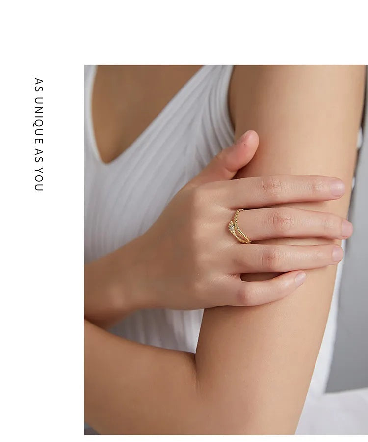Frau trägt goldenen Ring mit Diamanten, elegantes Schmuckdesign, Nahaufnahme, weißes Kleid.