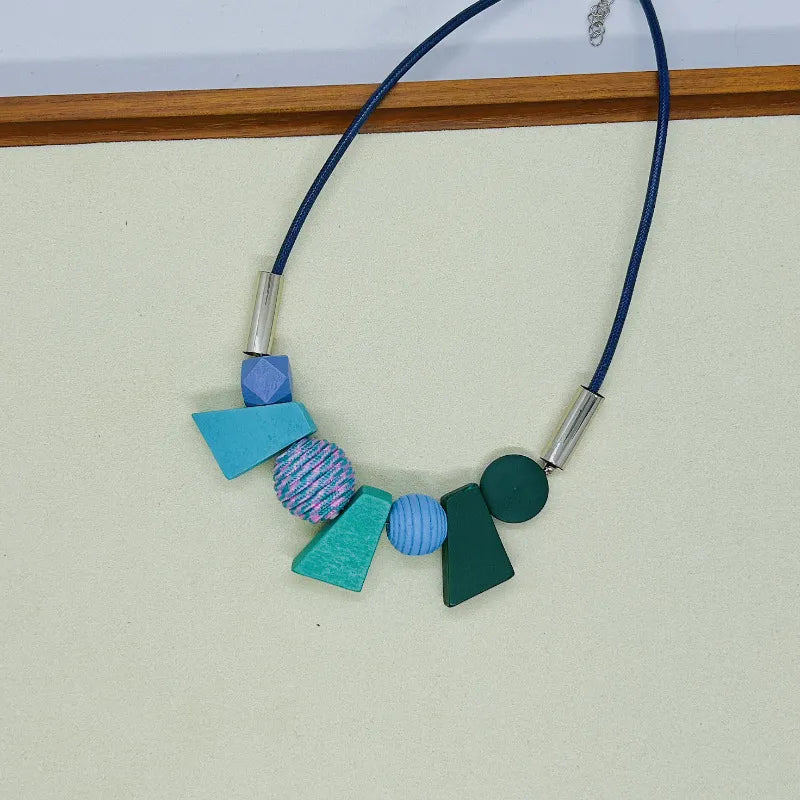 Bunte geometrische Halskette, handgefertigt, Holzperlen, blaues Band, modisches Accessoire.