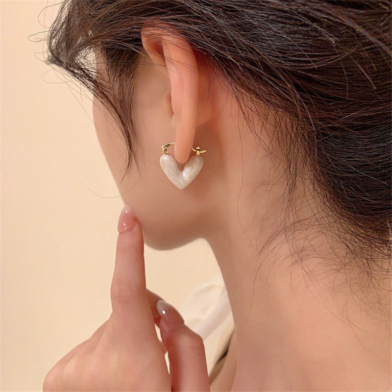 Frau mit weißen Herz-Ohrringen, koreanischer Stil, modisch, luxuriös, Schmuck für Frauen.