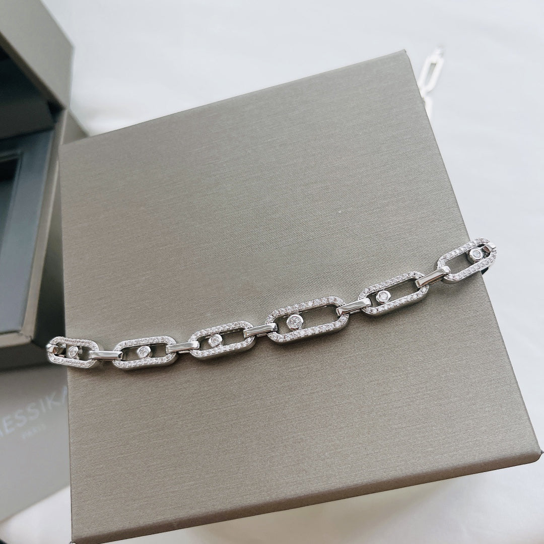 Luxuriöse silberne Halskette mit rechteckigen Gliedern und Diamantakzenten auf grauem Hintergrund.