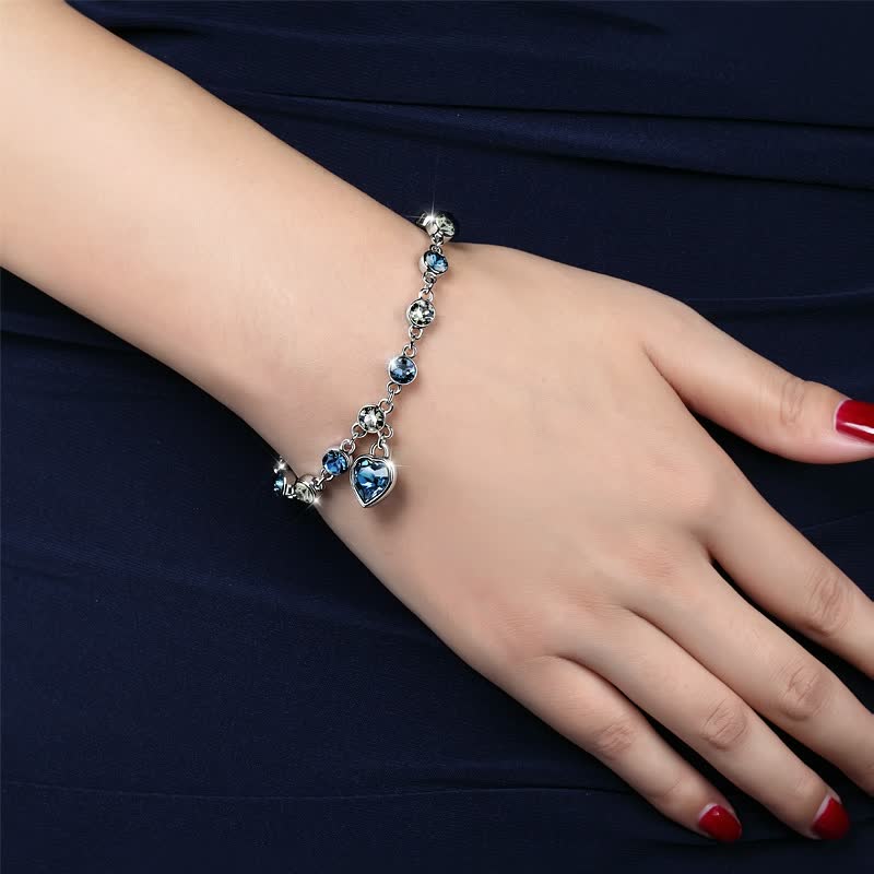 Silberarmband mit blauen Kristallen und Herzanhänger, eleganter Schmuck für Damen.