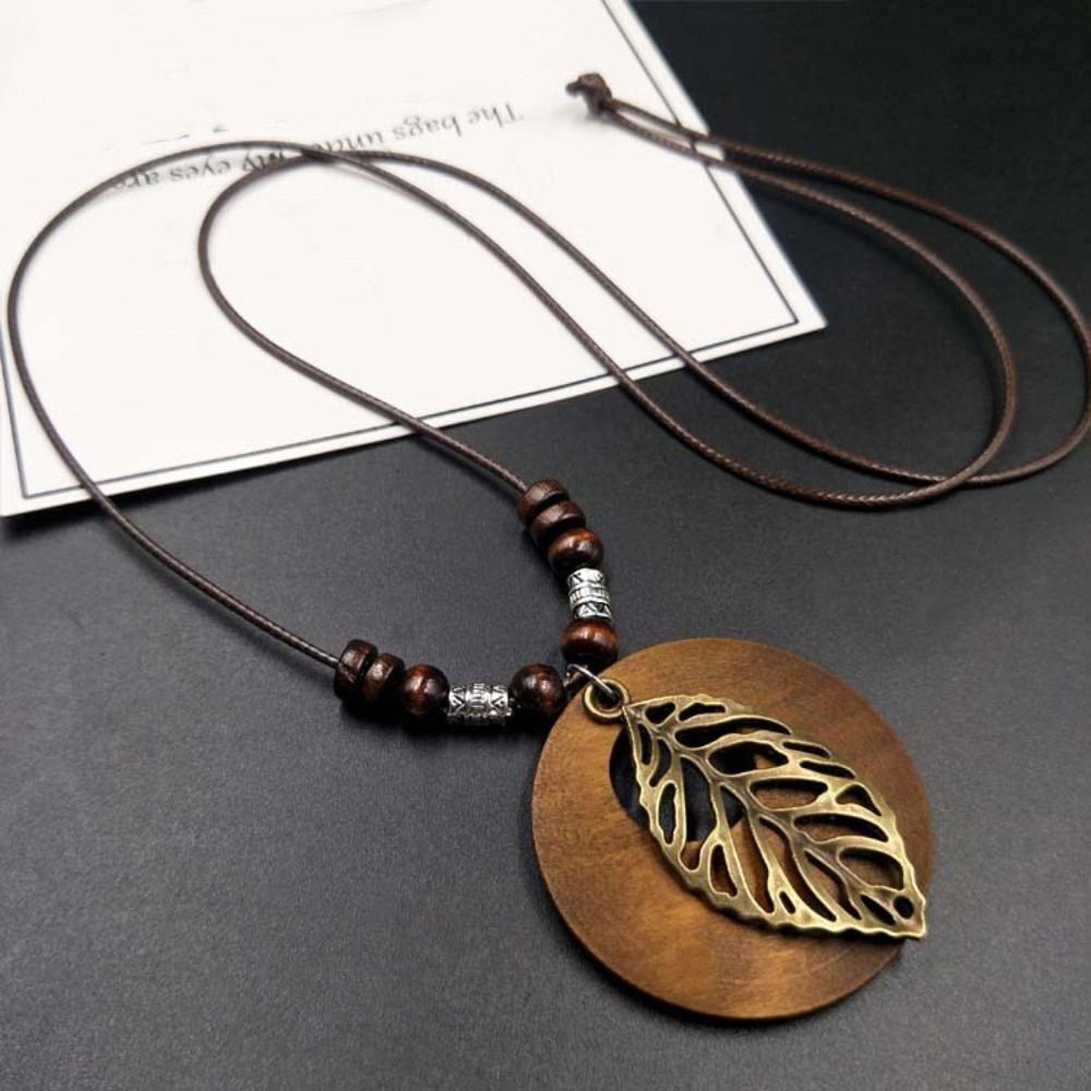 Braune Halskette mit Holzperlen und Metallblatt-Anhänger, Boho-Stil, handgefertigt.