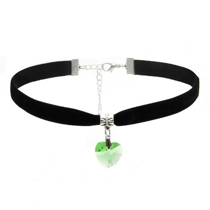 Schwarzer Samt-Choker mit grünem Herzanhänger, gotischer Stil, modisches Accessoire.