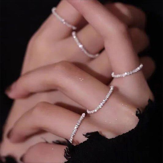 Damenhand mit eleganten, silbernen Ringen, funkelnde Schmuckstücke, modisches Accessoire.