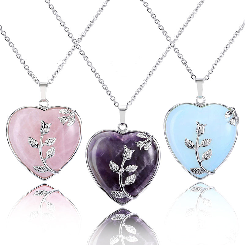Drei herzförmige Anhänger aus Rosenquarz, Amethyst, Opal mit Silberkette und Blumenmotiv.