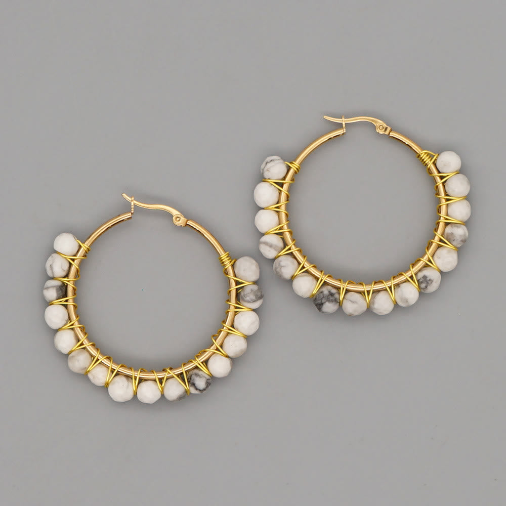 Goldene Creolen mit weißen Marmorperlen, handgefertigter Schmuck, elegantes Design.
