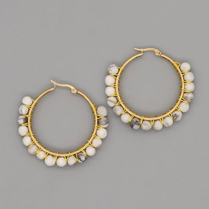 Goldene Creolen mit weißen Marmorperlen, handgefertigter Schmuck, elegantes Design.