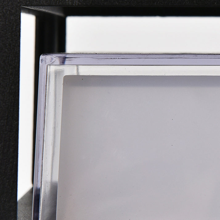 Detalje af skærmens klare plastkant omkring den matte hvide diffusor, set foran den sorte ramme. 6