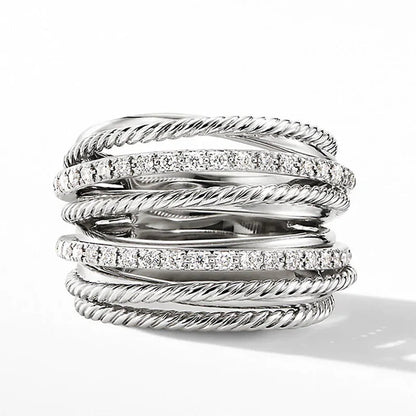 Silberring mit mehreren verdrehten Bändern und funkelnden Kristallen, elegantes Schmuckdesign.