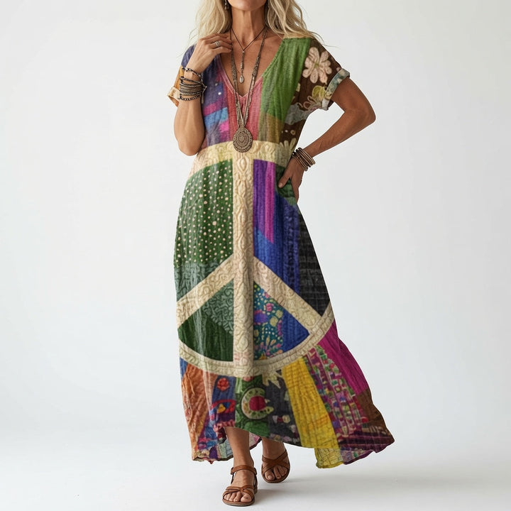 Kjolen i farverigt patchworkdesign med stort fredstegn på forstykket, båret af model med armbånd og brune sandaler. 2