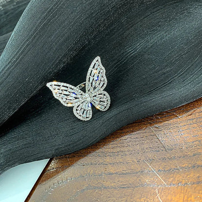 Silberner Schmetterlingsring mit Kristallen auf schwarzem Stoff, eleganter Schmuck, Damenaccessoire.
