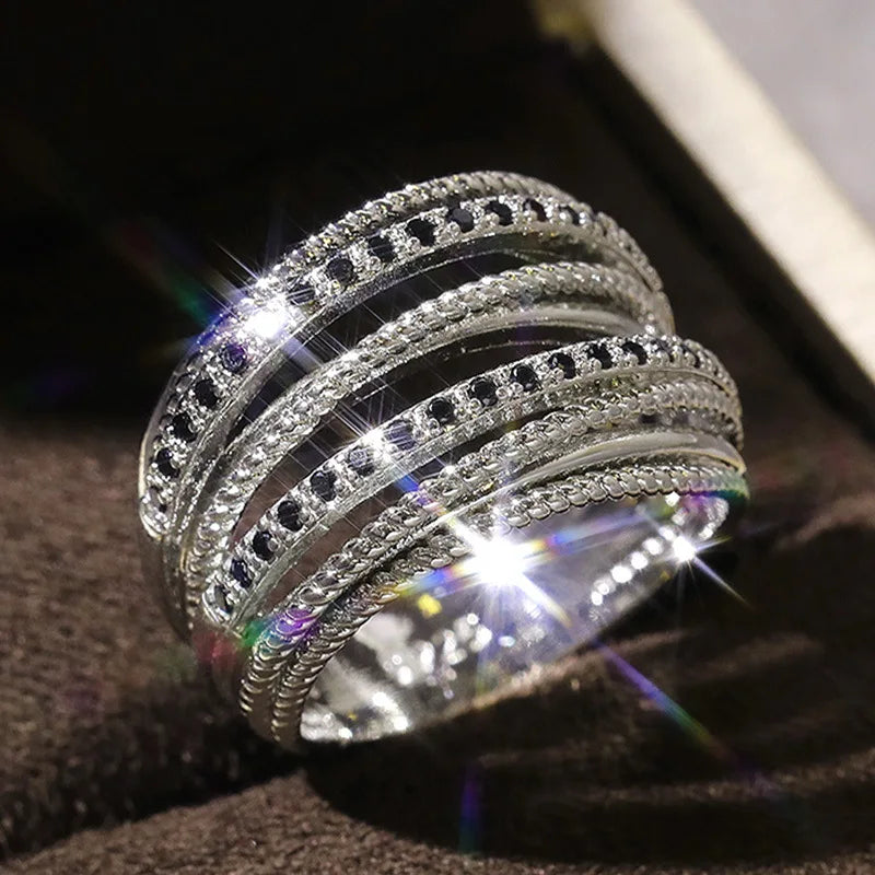 Silberring mit schwarzen Kristallen, funkelnd, mehrschichtig, elegantes Schmuckdesign.