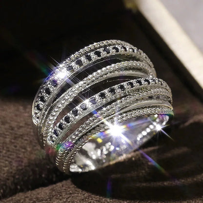 Silberring mit schwarzen Kristallen, funkelnd, mehrschichtig, elegantes Schmuckdesign.