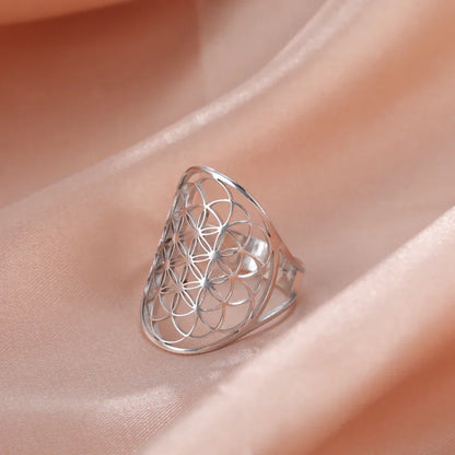 Silberring mit geometrischem Muster auf rosa Stoff, eleganter Schmuck, modisches Accessoire.