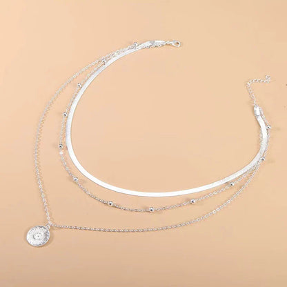 Silberne Halskette mit Sonnenanhänger, mehrlagig, Damenmode, Schmuckaccessoire, elegant.