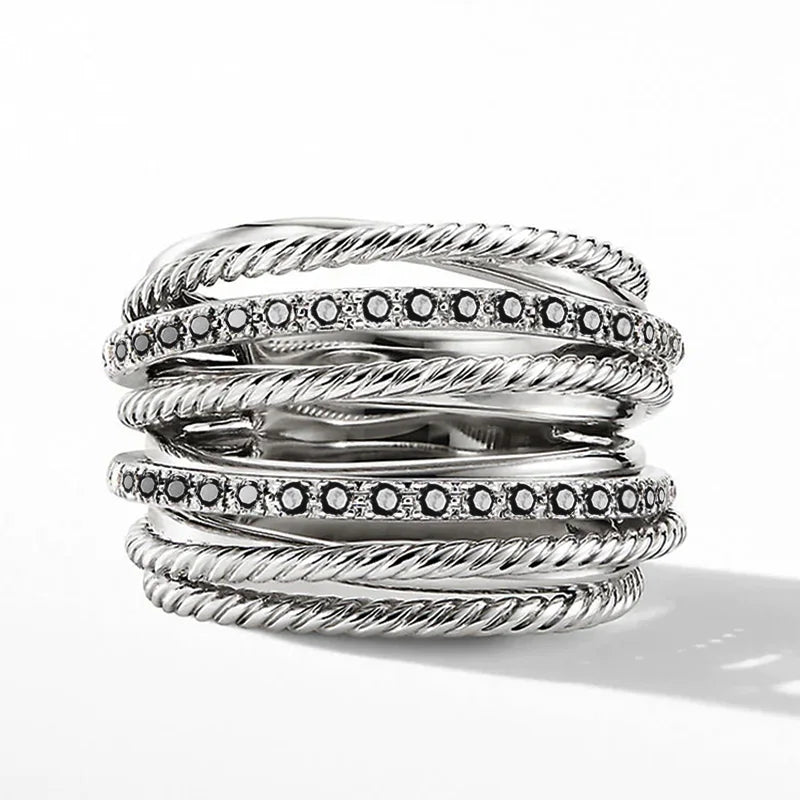 Silberring mit schwarzen Diamanten, gedrehte Bänder, elegantes Schmuckdesign, luxuriöses Accessoire.