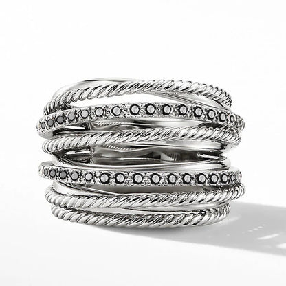 Silberring mit schwarzen Diamanten, gedrehte Bänder, elegantes Schmuckdesign, luxuriöses Accessoire.