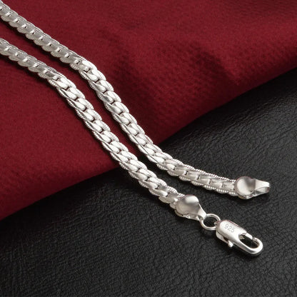Silberne Halskette 925 Sterling Silber, flach, auf rotem Stoff, Schmuck für Damen und Herren.