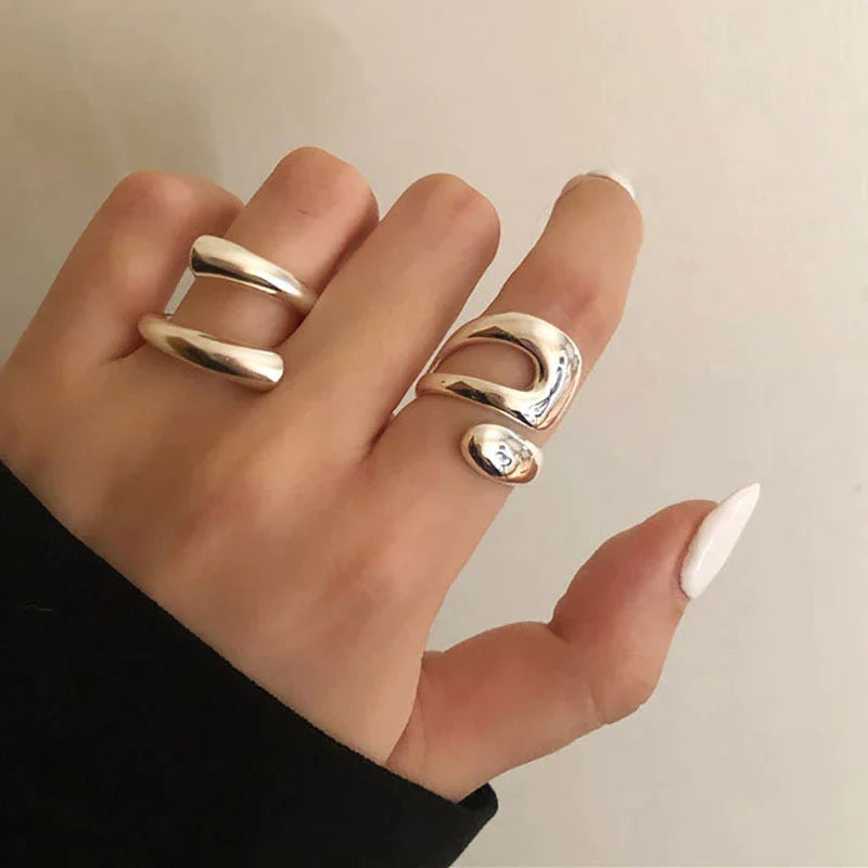 Drei silberne Ringe an Hand, minimalistisches Design, glänzend, modischer Schmuck.