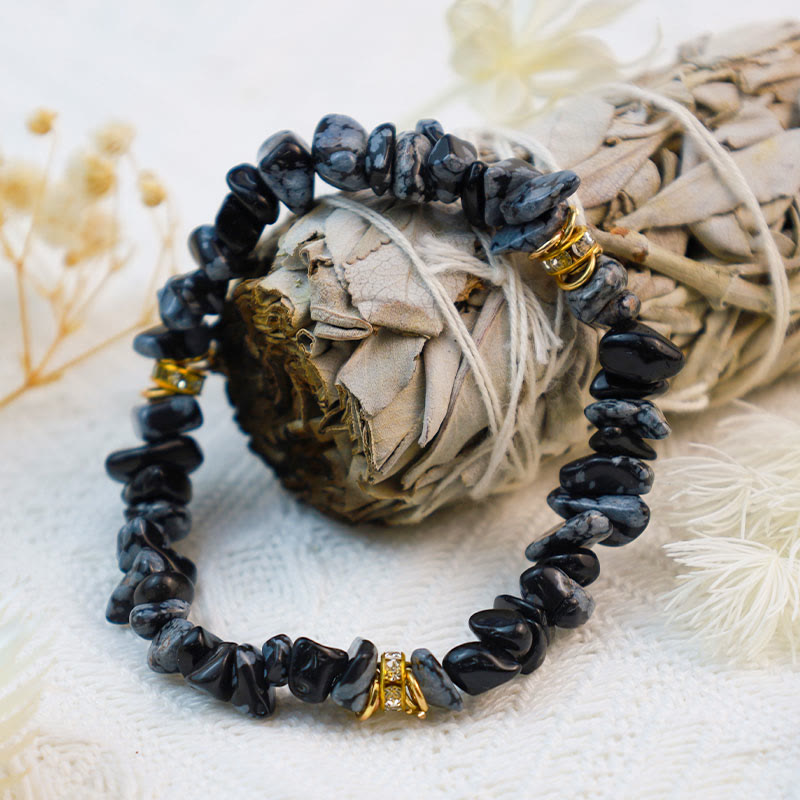 Schwarzes Edelsteinarmband mit goldenen Akzenten auf weißem Hintergrund, Schmuck, Modeaccessoire.