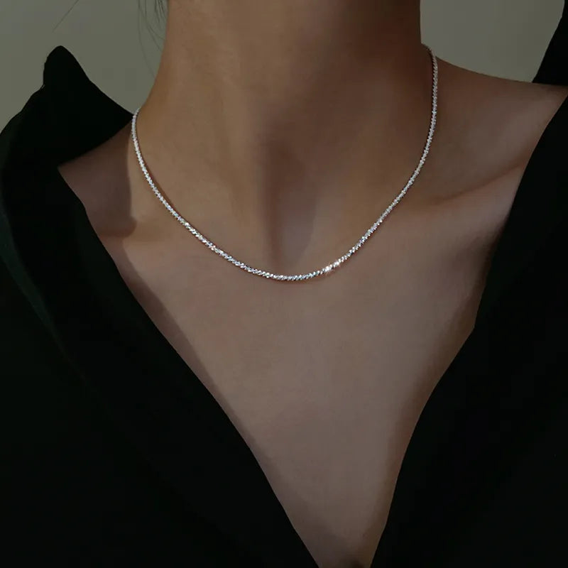 Silberne Halskette Damen, minimalistisches Design, eleganter Schmuck, schwarzes Oberteil.