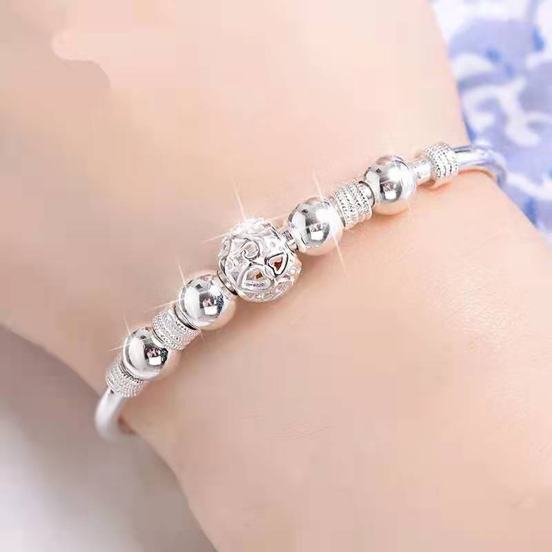 Silberarmband mit glänzenden Kugeln und filigranem Design, eleganter Schmuck für Damen.