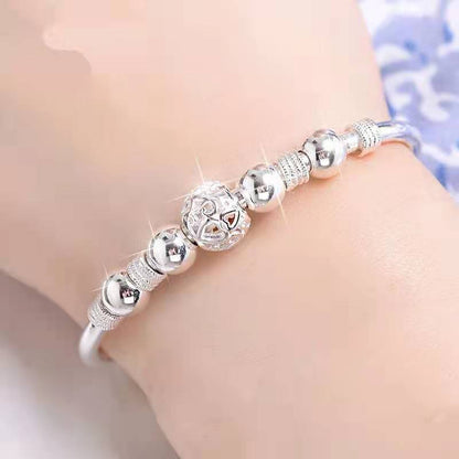 Silberarmband mit glänzenden Kugeln und filigranem Design, eleganter Schmuck für Damen.