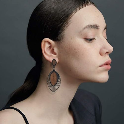 Frau mit eleganten, großen Ohrringen aus Holz und Metall, modisches Accessoire, Seitenansicht.