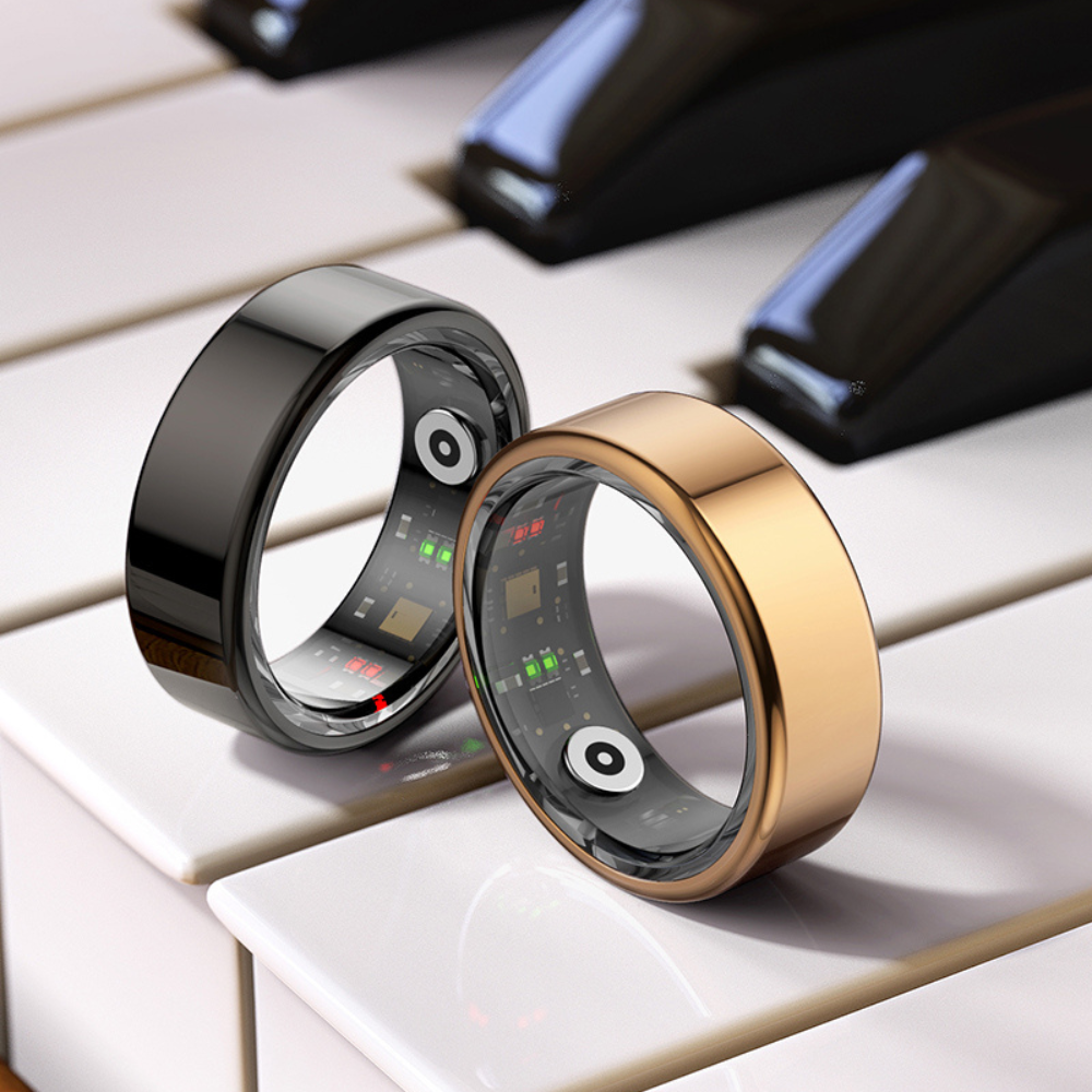 Zwei Smart-Ringe, schwarz und gold, auf Klaviertasten, moderne Technologie, stilvolles Design.