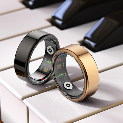 Zwei Smart-Ringe, schwarz und gold, auf Klaviertasten, moderne Technologie, stilvolles Design.