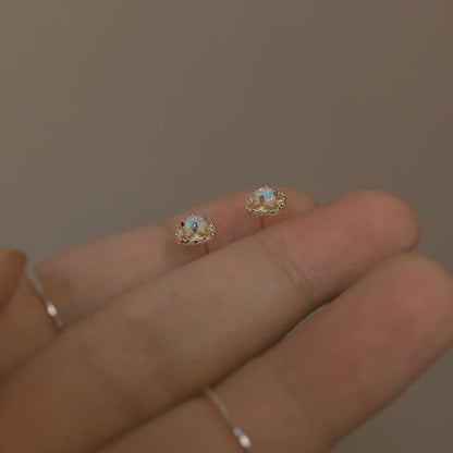 Opal Ohrringe auf Hand, goldfarben, zierlich, Schmuck, Damenaccessoire, elegantes Design.