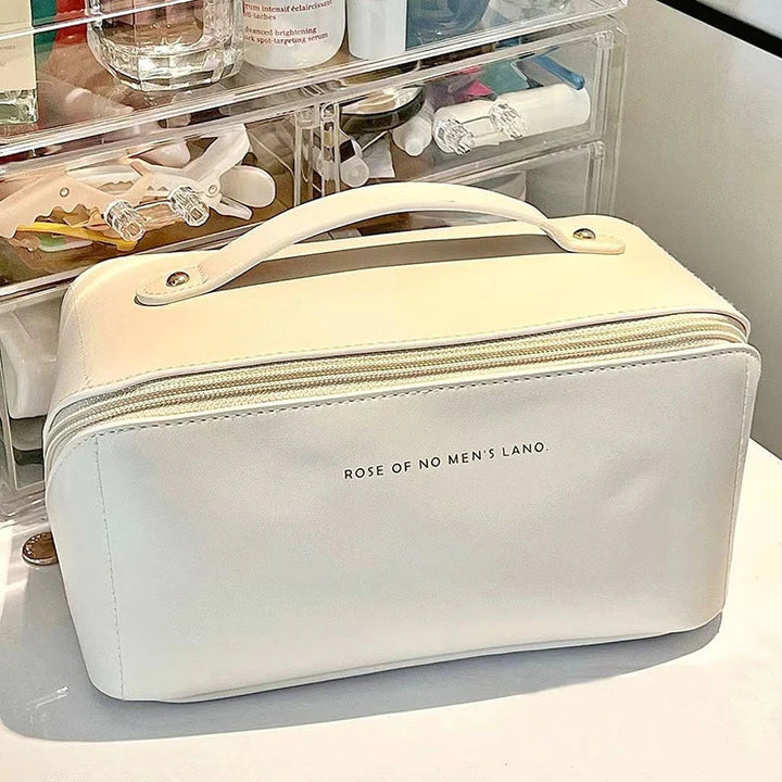 Weiße Kosmetiktasche aus Leder mit Reißverschluss und Tragegriff auf Schminktisch.