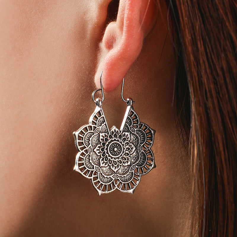 Silberne Mandala-Ohrringe, filigranes Design, Damen-Schmuck, Boho-Stil, Nahaufnahme.