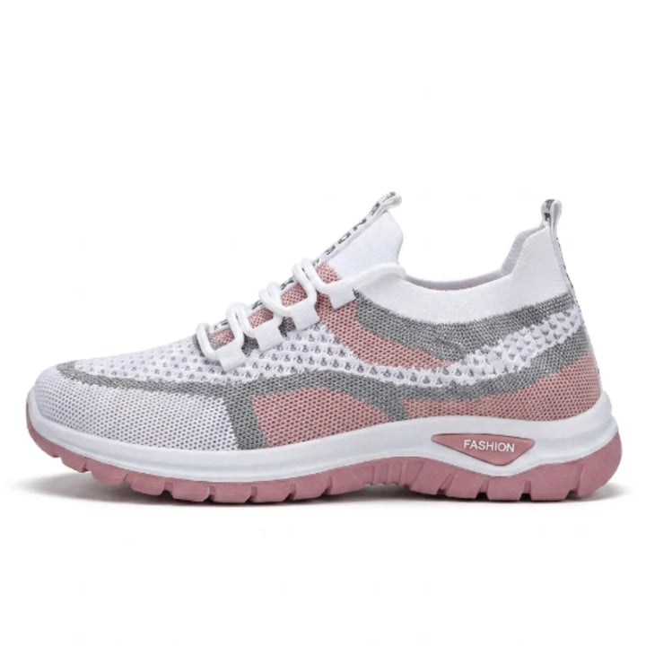 Sneaker i hvidt mesh med grå striber og rosa felter og sål, set fra siden. 19