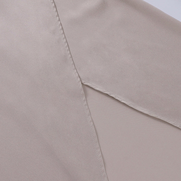 Seidenbluse beige Detailansicht, glatter Stoff, elegante Damenmode, hochwertige Verarbeitung.