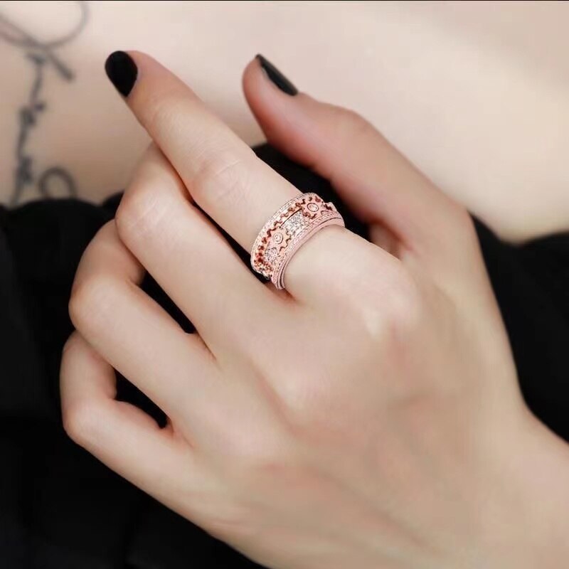 Damenhand mit roségoldenem mechanischem Zahnradring, luxuriöser Schmuck, Entspannungsring.