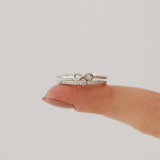 Silberner Unendlichkeitsring mit Diamanten auf Finger, eleganter Schmuck, Verlobungsring.