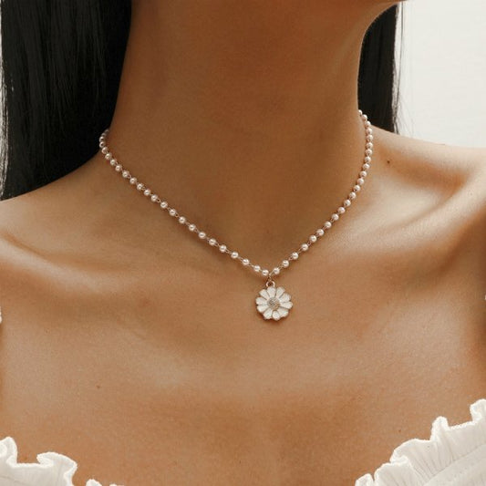 Perlenkette mit Blumenanhänger, eleganter Schmuck, Damenmode, weiß, stilvoll, Accessoire.