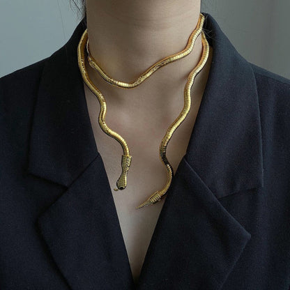 Goldene Schlangen-Halskette, Damenmode, elegantes Schmuckdesign, schwarzer Blazer-Hintergrund.